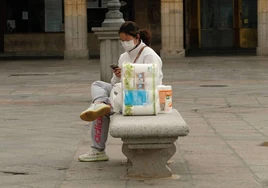Una mujer con una bolsa de papel higiénico en Salamanca.