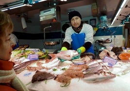 Un pescadero del mercado con un pargo.