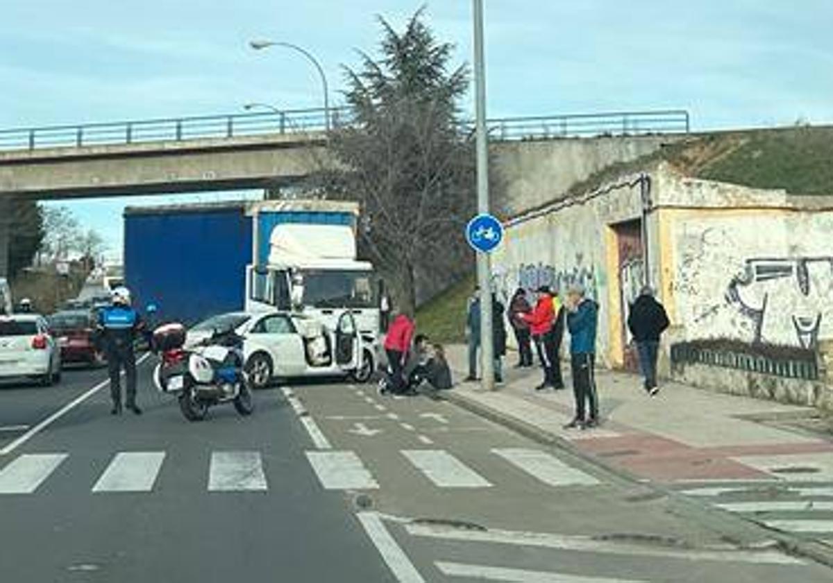 Un agente regula el tráfico en la zona junto a los vehículos implicados en el accidente.