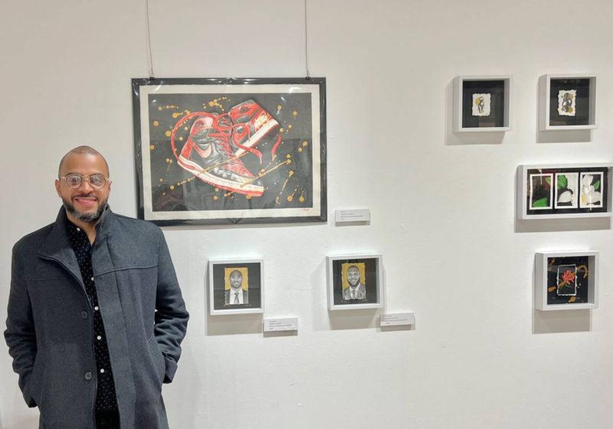 El artista, junto a su exposición.