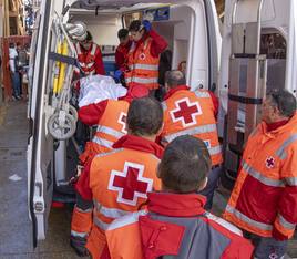 Operarios de la Cruz Roja atienden a un herido en la ambulancia