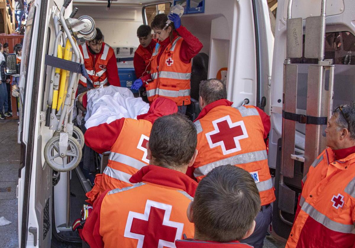 Operarios de la Cruz Roja atienden a un herido en la ambulancia