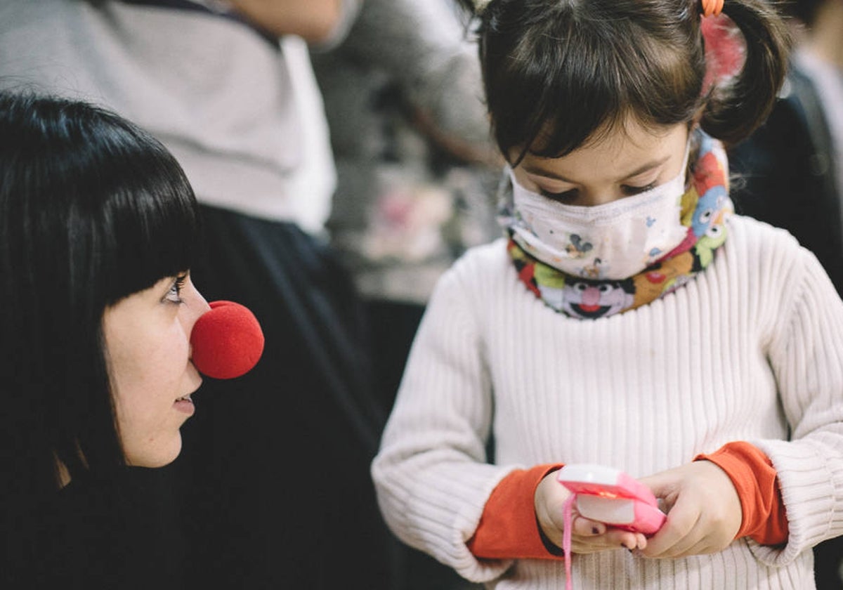 Una voluntaria juega con una niña hospitalizada.