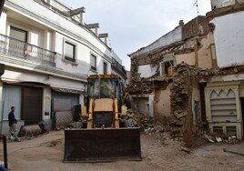 Máquina excavadora en el derribo de la casa en ruinas de la calle Manterola.