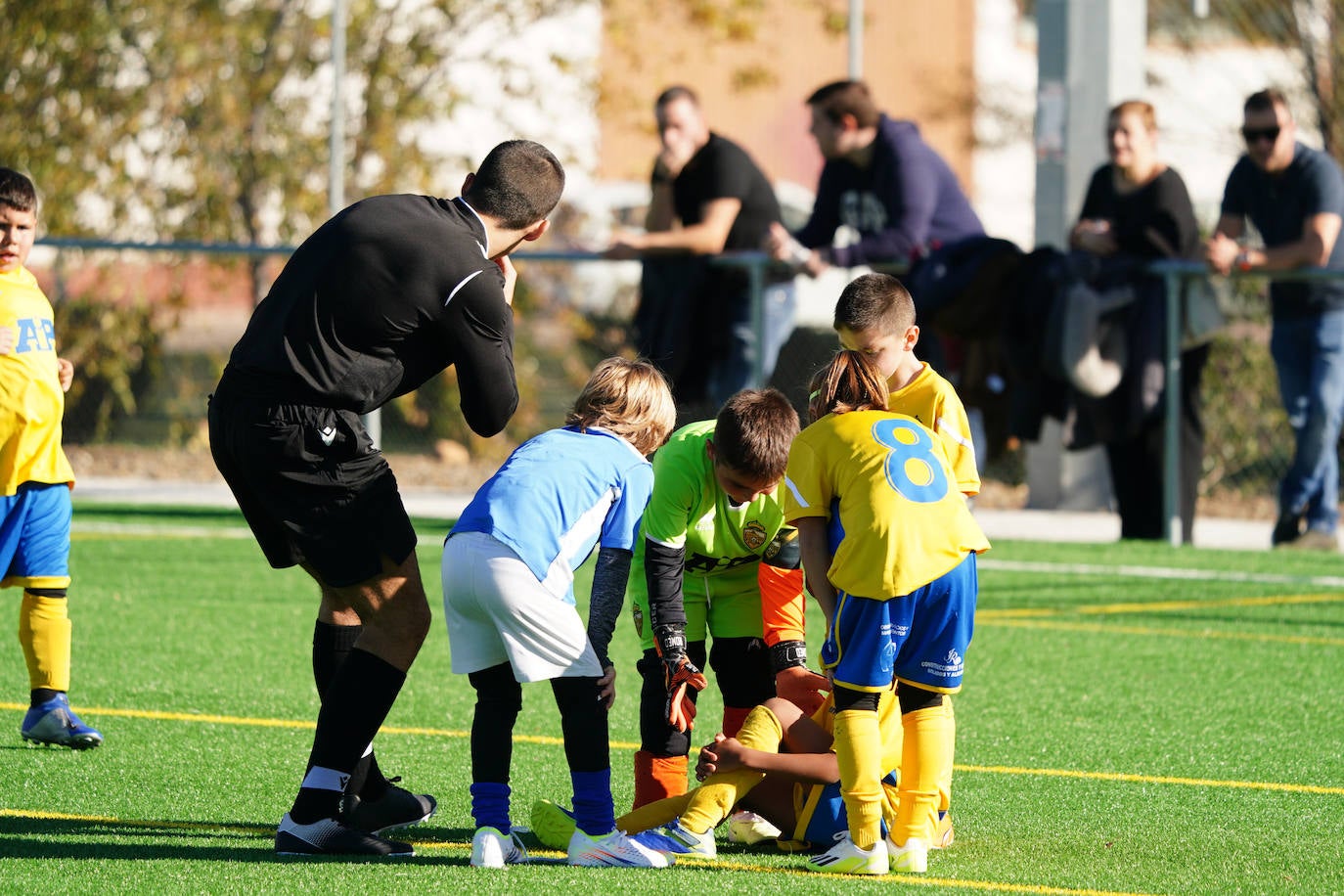 Un árbitro en plena labor durante un encuentro de fútbol base.