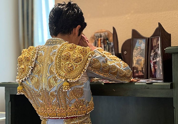 10:32 HORAS. Marco Pérez se queda en solitario, en un silencio sepulcral reza ante la capilla que tiene instalada en la propia habitación del hotel, con decenas de estampitas que le han ido regalando, aficionados y profesionales.