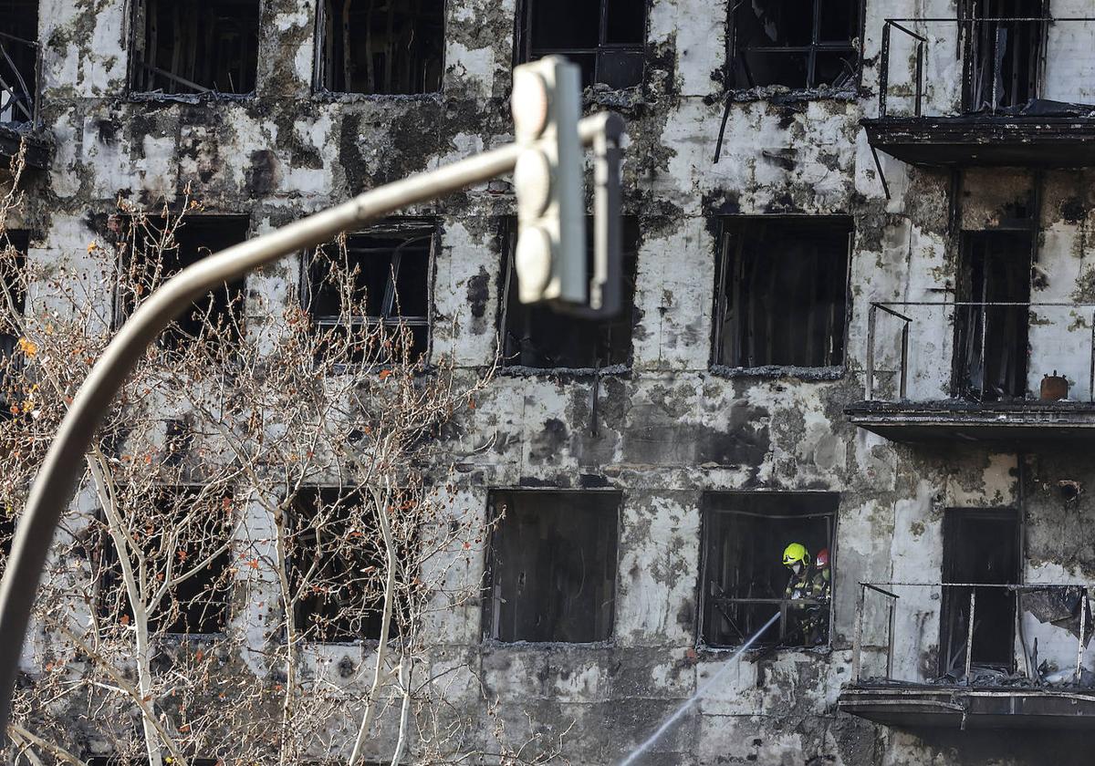 Un bombero trabaja en la labores de extinción del edificio incendiado en Valencia.