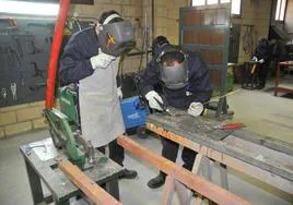 Dos participantes en un curso de carpintería metálica.