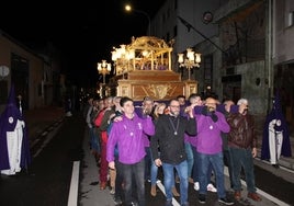 Hombres y mujeres portan a hombros al Cristo de la Cama