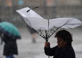 El viento destroza el pararagüas de una mujer.