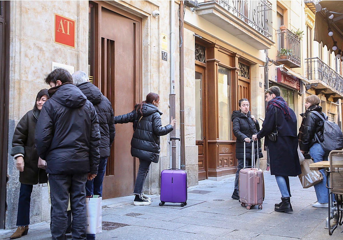 Usuarios de apartamentos turísticos, con sus maletas en una calle céntrica de la ciudad.
