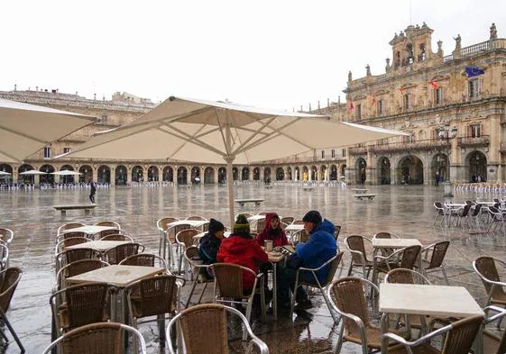Personas tomando algo en un a terraza de la Plaza Mayor en un día de lluvia