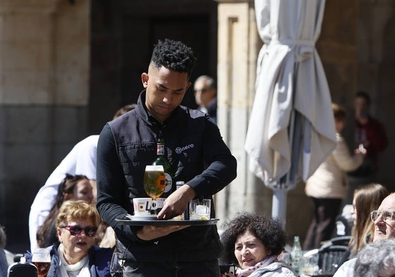 Un camarero sirve unas bebidas en el centro de la ciudad.