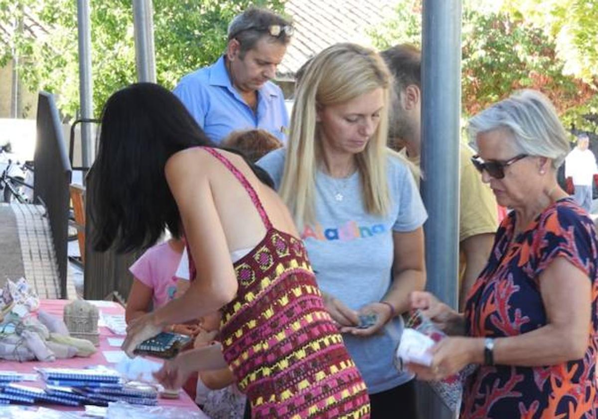 Vecinos participan en el mercadillo solidario.