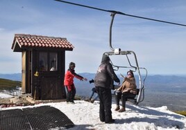 Imagen de trabajadores durante la temporada de esquí ayudando al público a descender del telesilla.