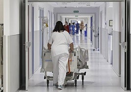 Una trabajadora del Hospital de Salamanca mueve una camillas por los pasillos del edificio.
