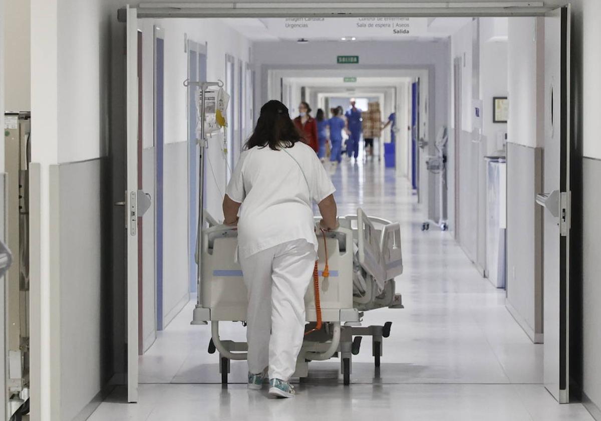 Una trabajadora del Hospital de Salamanca mueve una camillas por los pasillos del edificio.