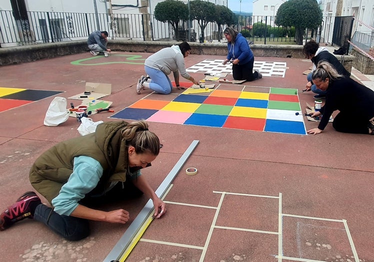 Imagen principal - Las madres y la directora, aportando su granito de arena.