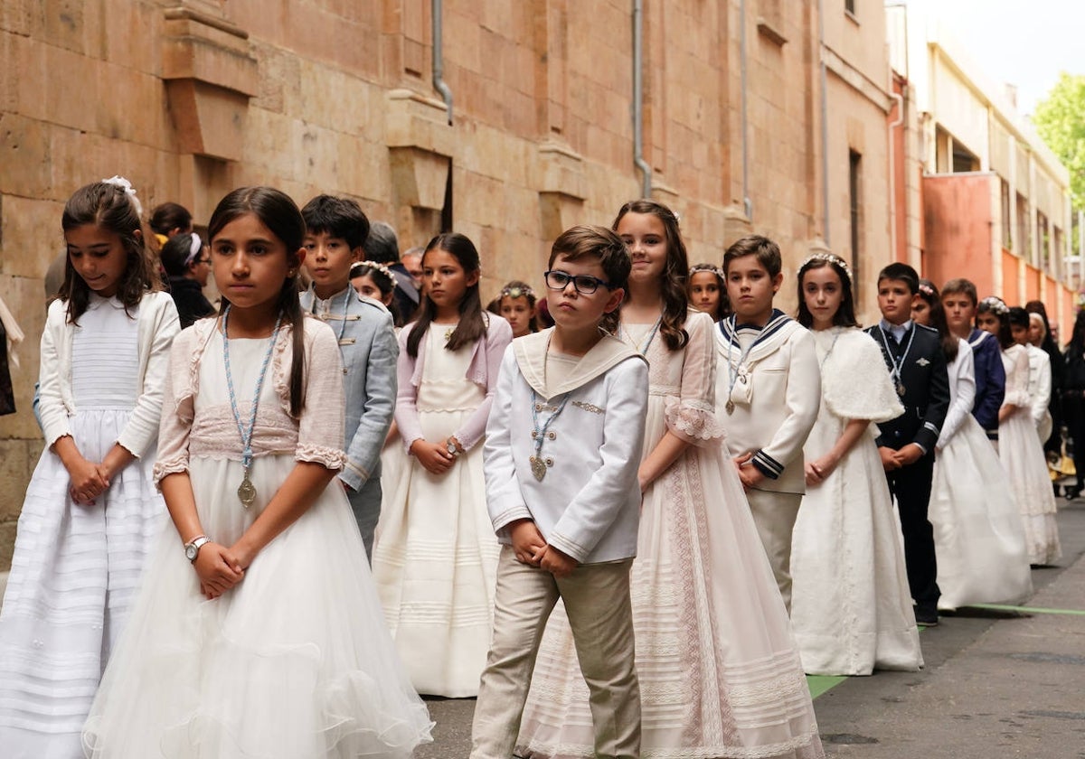 Un grupo de niños de comunión en una procesión.