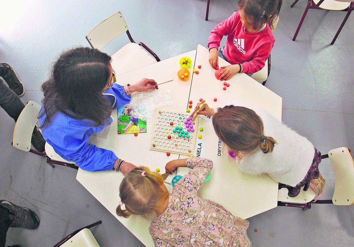 Jóvenes ucranianos realizan juegos de aprendizaje en un colegio.