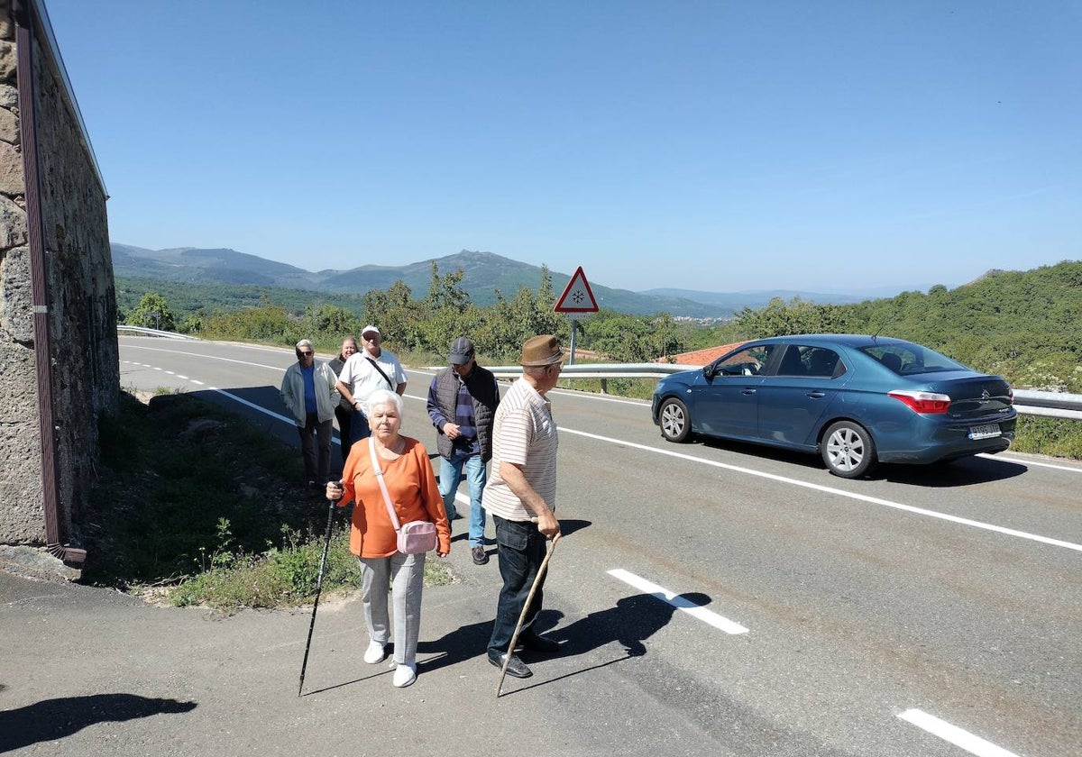 Vecinos de La Hoya caminan por el arcén de la carretera que se va a ensanchar para mejorar la seguridad.