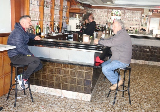 Dos vecinos charlan en el bar de su pueblo.