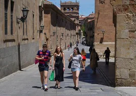 Estudiantes paseando con camisetas y pantalones cortos.