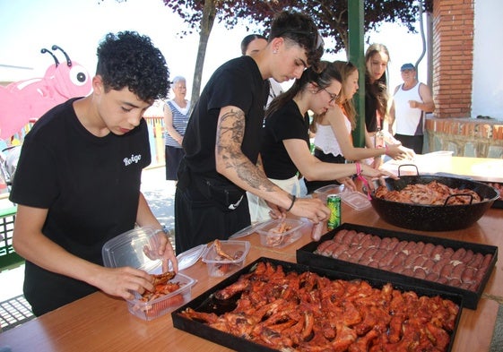 Los peñistas ayudando en la preparación de las raciones de parrillada