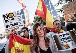 Unos manifestantes en la puerta del juzgado con una imagen a tamaño real de Begoña Gómez