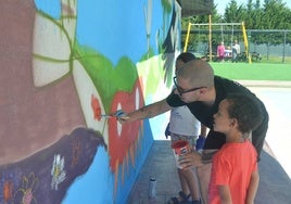 El artista urbano Nadie, junto a los participantes en el mural en el turno de tarde.