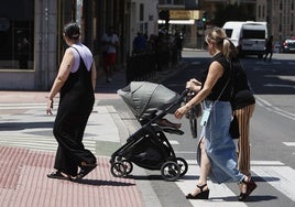 Tres mujeres con un carro de bebé.