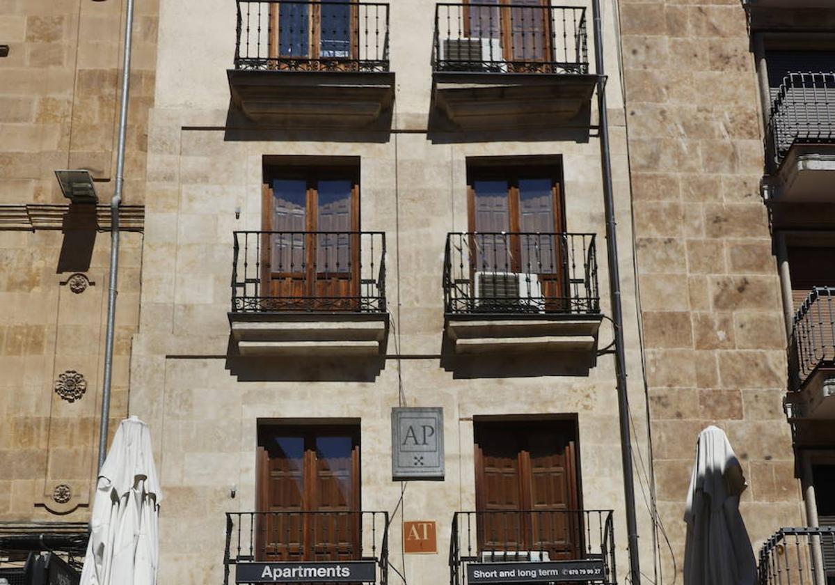 Una mujer pasa frente a un edificio de apartamentos turísticos.