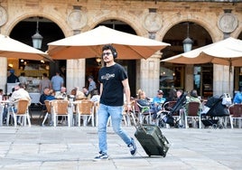 Un turista cruza la Plaza Mayor de Salamanca con una maleta.