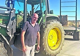 Andrés Monje, junto al tractor con el que transporta paja.