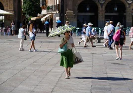 Una mujer se protege del calor en el centro de Salamanca con un paraguas.