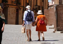 Una pareja de turistas bajo el sol de agosto por el centro de la ciudad.