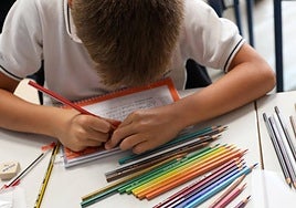 Un niño colorea en un colegio.