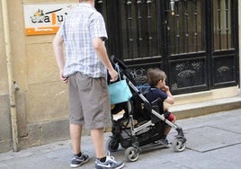 Un padre, con un carrito de bebé, por la capital.