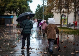 Dos personas se protegen de la lluvia.