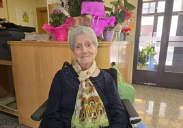 Carmen Álvarez en la entrada de la residencia, junto a los ramos de flores de su cumpleaños.