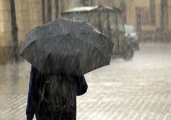 Una persona se protege de la lluvia con un paraguas.