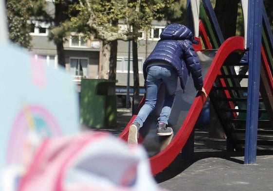 Un niño en un parque jugando en un tobogán.