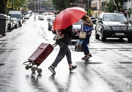 Varias personas intentan esquivar la lluvia.