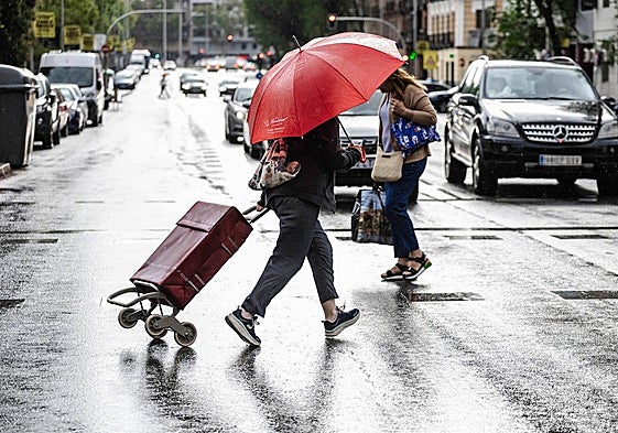 Varias personas intentan esquivar la lluvia.