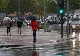 Los salmantinos se resguardan de la lluvia con paraguas este lunes.