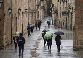 Ciudadanos por Salamanca bajo la lluvia.