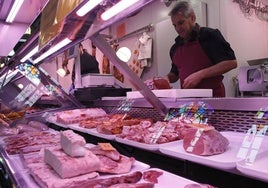 Un carnicero corta uno filetes de ternera en el Mercado.