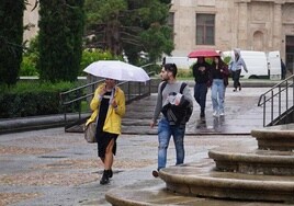 Jóvenes caminando bajo la lluvia en Salamanca.