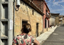 Una vecina observa el edicto publicado por el Ayuntamiento.