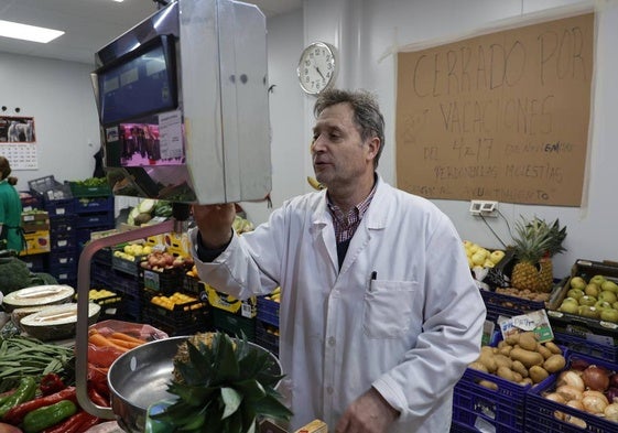 Carlos Iglesias atendiendo a los clientes en su frutería.